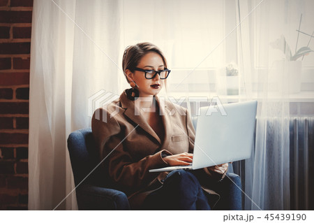girl in blazer and glasses working withlaptop computer girl in blazer and glasses working withlaptop computer 45439190