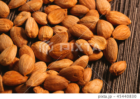 Apricot kernels are scattered on the wooden 45440830
