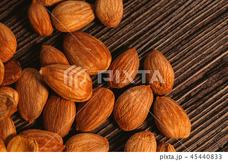 Apricot kernels are scattered on the wooden 45440833