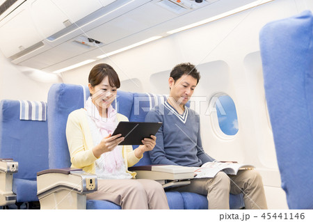 飛行機 機内 旅行 夫婦 機内ショッピング 免税の写真素材