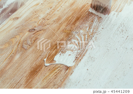 closeup hand use brush paint white on wood surface closeup hand use brush paint white on wood surface 45441209