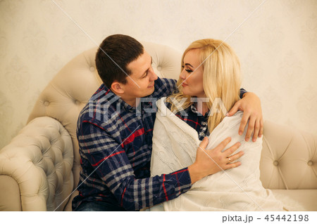 Happy couple in holiday spirit showing affection for one another. Dressed in plaid clothes. Gentle 45442198
