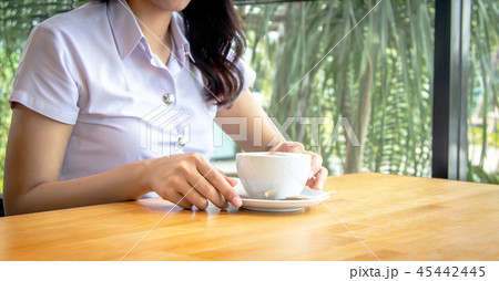 hand hold spoon to mix hot coffee foam on cup hand hold spoon to mix hot coffee foam on cup 45442445