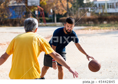 Father and son playing basketball in the park Father and son playing basketball in the park 45442845