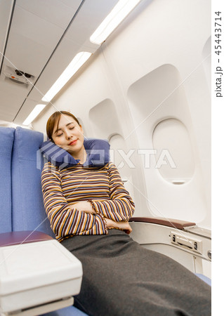 飛行機 機内 旅行 女性 寝るの写真素材