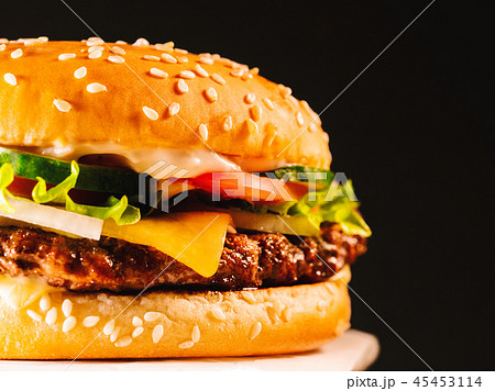 Juicy beef burger with cutlet, onion, vegetables, melted cheese, lettuce, sauce and topped sesame 45453114