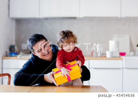 Father and son holding a gift box for Christmas Father and son holding a gift box for Christmas 45454636