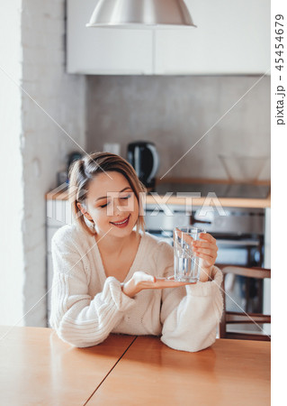Young girl in sweater with glass of water 45454679