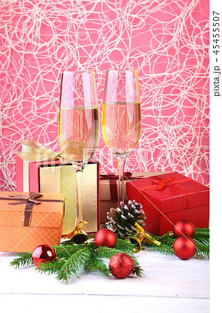 New Year or Christmas decorations with glasses wine, gift boxes, candles and balls. greeting card New Year or Christmas decorations with glasses wine, gift boxes, candles and balls. greeting card 45455507