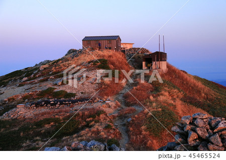 東北飯豊連峰　飯豊山山頂直下本山小屋の朝　朝陽に映える本山小屋と飯豊山神社　 45465524