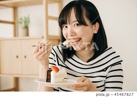 ケーキを食べる若い日本人女性の写真素材