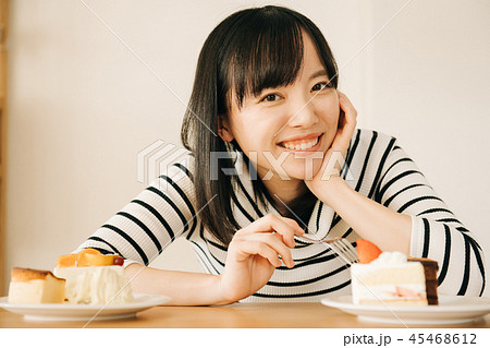 ケーキをたくさん食べる若い日本人女性の写真素材