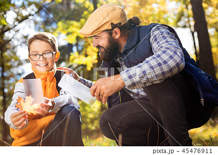 Nice positive man and his son holding smartphones Nice positive man and his son holding smartphones 45476911