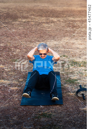 Senior doing crunches outdoors Senior doing crunches outdoors 45477462