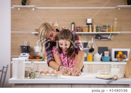 Portrait of excited mom and daughter having fun while cooking 45480596