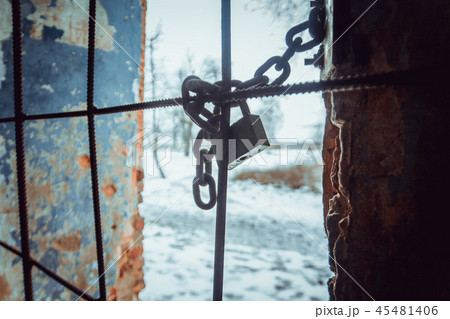 Padlock and sturdy steel chain wrapped around metal rods on window Padlock and sturdy steel chain wrapped around metal rods on window 45481406