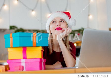 girl with a gift boxes and laptop computer order something  45487003
