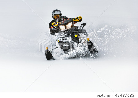 In deep snowdrift snowmobile rider make fast turn 45487035