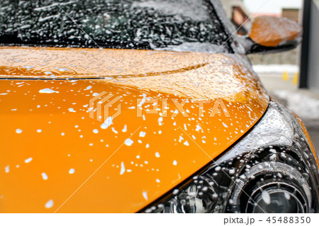 Yellow car front covered with shampoo foam carwash Yellow car front covered with shampoo foam carwash 45488350