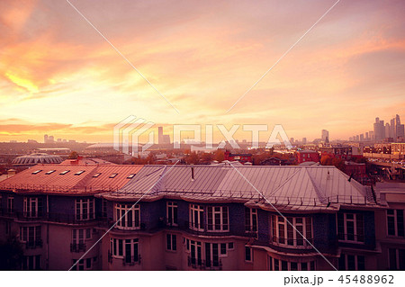 Clouds of beautiful color against the roofs of houses. Sunset pink red orange. Clouds of beautiful color against the roofs of houses. Sunset pink red orange. 45488962