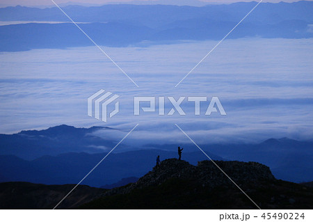 東北飯豊山 山頂直下本山小屋から 一ノ王子登山者シルエットと朝焼けと雲海の下に眠る会津の街 東北飯豊山 山頂直下本山小屋から 一ノ王子登山者シルエットと朝焼けと雲海の下に眠る会津の街 45490224