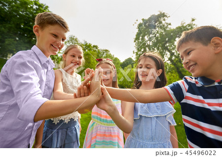 group of happy kids making high five outdoors 45496022