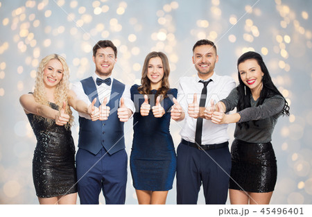 happy friends in party clothes showing thumbs up 45496401
