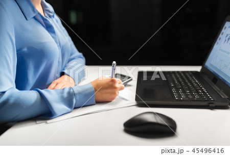 businesswoman with papers working at night office businesswoman with papers working at night office 45496416