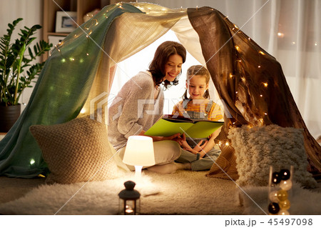 happy family reading book in kids tent at home 45497098