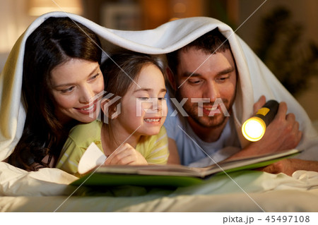 happy family reading book in bed at night at home happy family reading book in bed at night at home 45497108