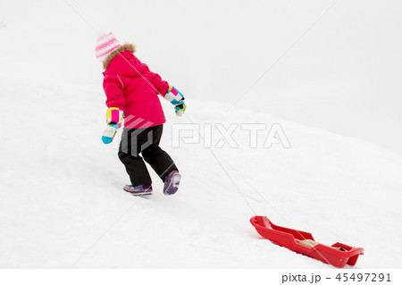 little girl with sled on snow hill in winter 45497291