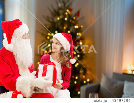 girl and santa with christmas gifts at home girl and santa with christmas gifts at home 45497294