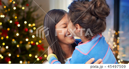 happy daughter kissing her mother on christmas 45497509