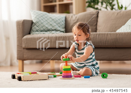 happy baby girl playing with toy blocks at home 45497545