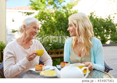 daughter with senior mother drinking tea at cafe 45497561