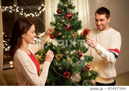 happy couple decorating christmas tree at home 45497564