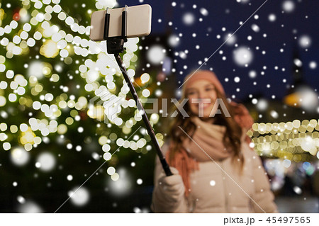 young woman taking selfie at christmas town 45497565