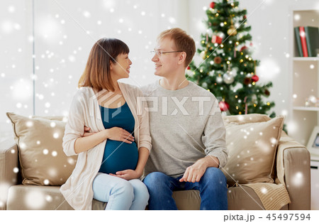 pregnant wife with husband at home at christmas 45497594