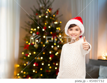 happy boy in santa hat showing thumbs up 45497732