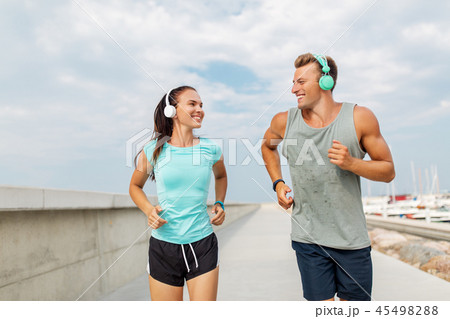 couple with headphones running outdoors couple with headphones running outdoors 45498288
