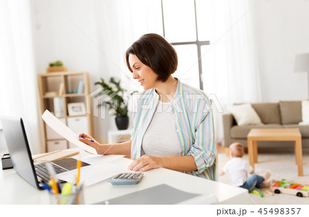 mother working at laptop and baby boy at home mother working at laptop and baby boy at home 45498357