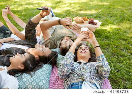 friends with smartphones chilling at summer park friends with smartphones chilling at summer park 45498738