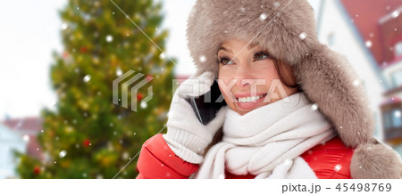 woman calling on smartphone over christmas tree woman calling on smartphone over christmas tree 45498769