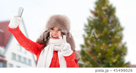 woman taking selfie over christmas tree woman taking selfie over christmas tree 45499026