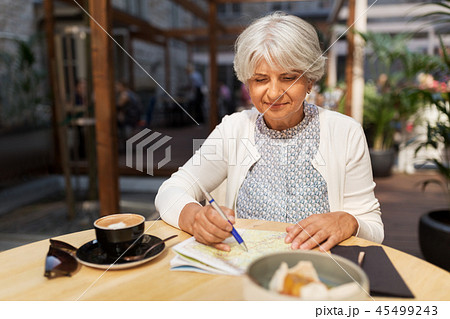 senior woman with map and coffee at street cafe 45499243