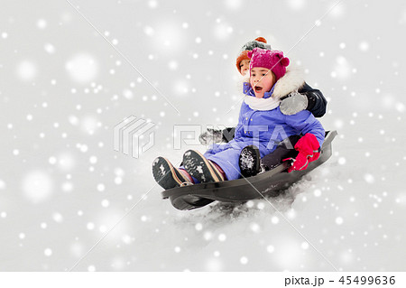 kids sliding on sled down snow hill in winter kids sliding on sled down snow hill in winter 45499636