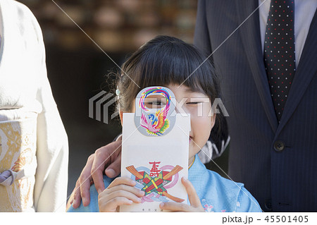 七五三イメージ　千歳飴の持ち手から覗き込む子供 45501405