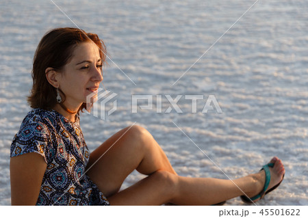 happy smiling girl enjoying the sunset sun and shakes her head, sits on the salt 45501622