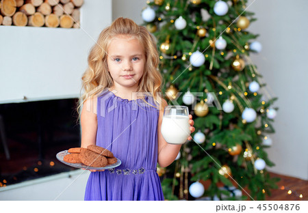 A little girl with blond hair prepared treats for Sanda. Christmas background, new year concept A little girl with blond hair prepared treats for Sanda. Christmas background, new year concept 45504876