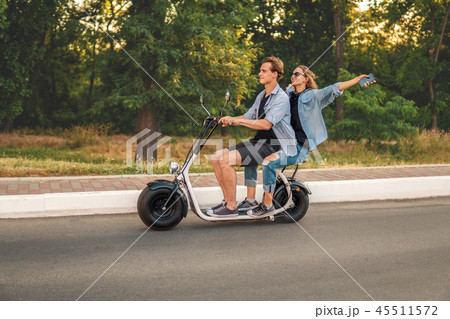 Lovely young couple driving electric bike during summer 45511572
